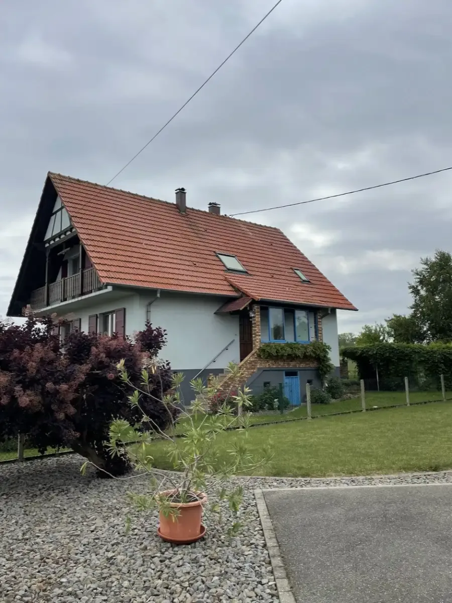 Maison avec une toiture en tuiles orangées et deux fenêtres de toit